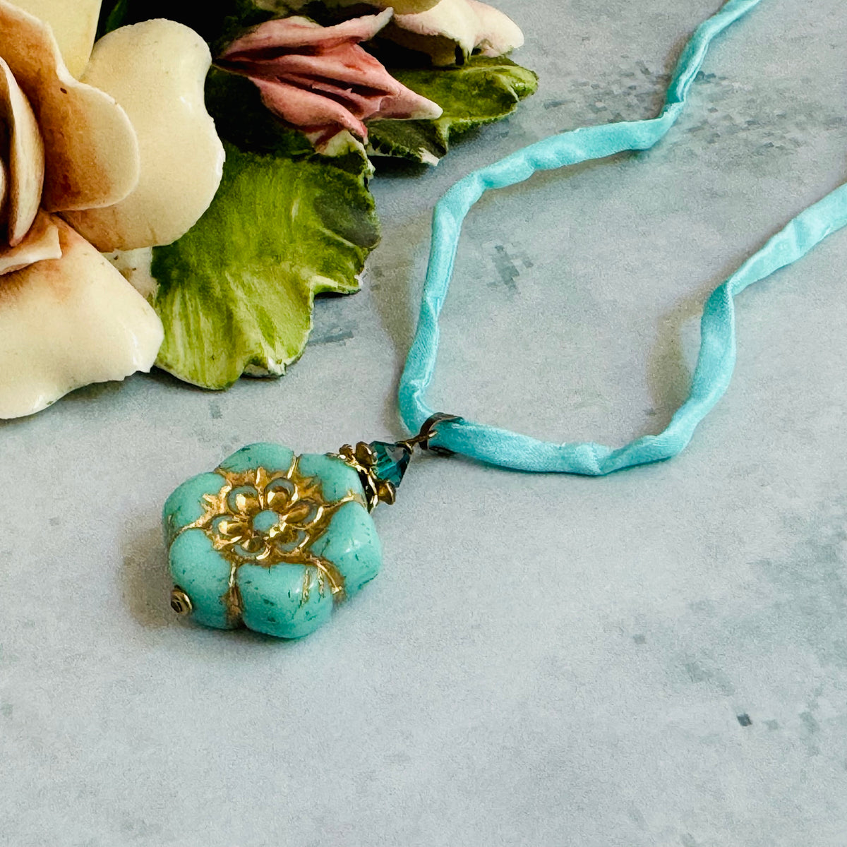 Light Teal Czech Glass Flower Pendant Necklace on Silk Cord in Antique Brass