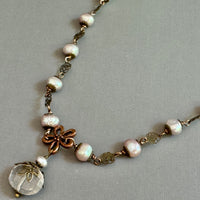 Necklace with pearls and decorative elements on a gray background